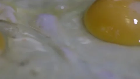 Frying an egg macro video Stock Footage 153547363