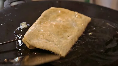 Frying egg martabak in a frying pan close up view Stock Footage 300621003