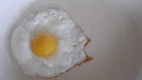 Frying egg in a pan Stock Footage 240856366