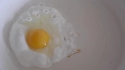 Frying egg in a pan Stock Footage 240856553