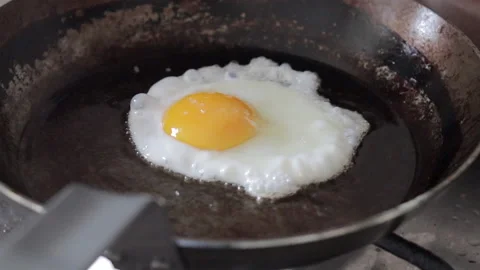 Frying an egg in a steel fryingpan Stock Footage 150808512