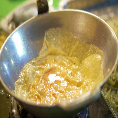 Frying egg in the wok while cooking Pad Thai at night market Stock Footage 69727712