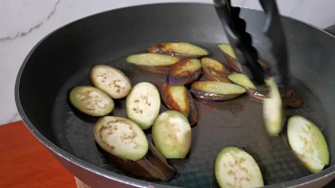 Frying Eggplants Slices on a Frying Pan with Minimal Cooking Oil Stock Footage 241512056