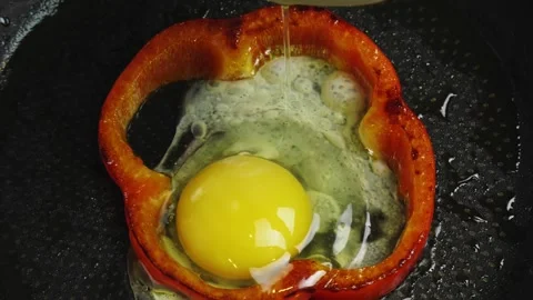 Frying eggs and red pepper in a frying pan Stock Footage 153524002
