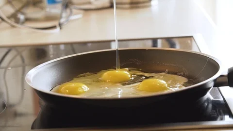 Frying eggs. Breaking an egg into frying pan Stock Footage 107216788