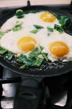Frying Eggs with Green Bell Pepper in Pan on Gas Stove, Homemade Breakfast .. Stock Photos