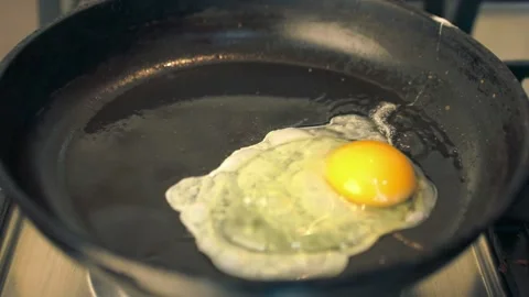 Frying eggs on kitchen pot Stock Footage 144056933