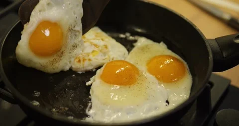 Frying eggs in a pan. Flipping the egg with a spatula Stock Footage 323201321