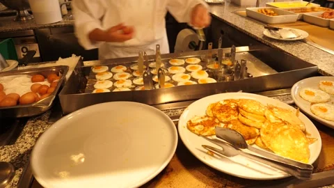 Frying eggs in round metal molds in the kitchen of a hotel restaurant 2 Stock Footage 294322275