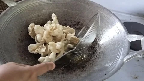 Frying Fish Crackers in Hot Oil Stock Footage 323907602
