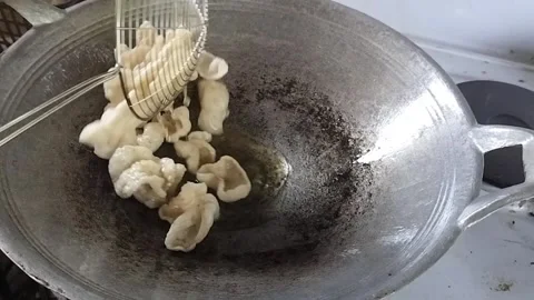 Frying Fish Crackers in Hot Oil Stock Footage 323907692