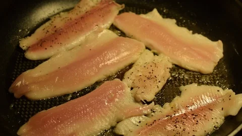 Frying fish fillets on frying pan and moving fillets with wooden spatula Stock-Footage 103362861