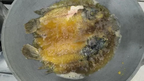 Frying Fish in Hot Boiling Oil inside Wok High Angle View Stock Footage 343639570