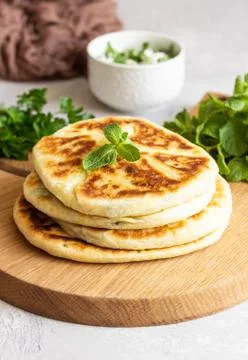Frying flatbread filled with herbs and cheese. Stock Photos