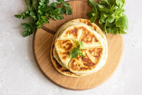 Frying flatbread filled with herbs and cheese. Stock Photos
