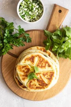 Frying flatbread filled with herbs and cheese. Stock Photos