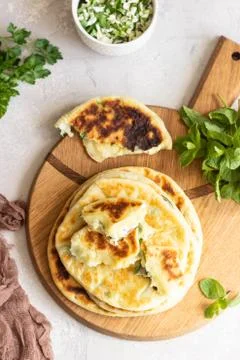 Frying flatbread filled with herbs and cheese. Stock Photos