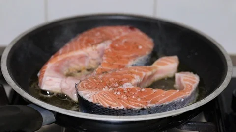 Frying fresh salmon in frying pan Stock Footage 105864409