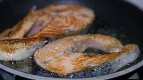 Frying fresh salmon in frying pan Stock Footage 105865590