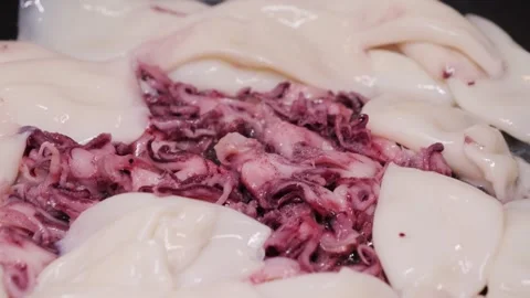 Frying the freshly cut squid in the hot pan with oil. Stock Footage 309567293