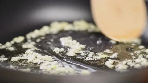 Frying of garlic in a frying pan with olive oil. Vídeos de archivo 154369962