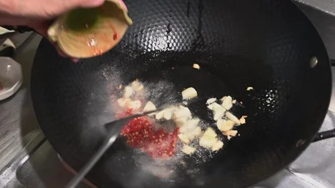 Frying Garlic to Release Its Aroma in a Black Pan Video stock 346488373