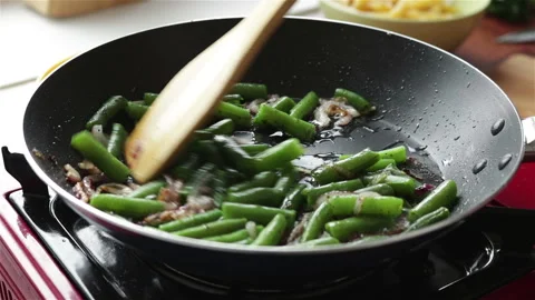 Frying green bean with onion in pan close up Stock Footage 135380169