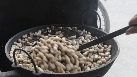 Frying ground nuts in sand in a large pot 스톡 동영상 142187455