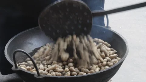Frying ground nuts in  sand in  a  large pot 스톡 동영상 142187538
