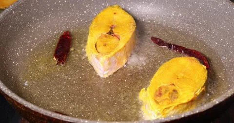 Frying hilsa fish cut pieces  Asian Bengali cooking oil with salt yellow tu.. Stock-Footage 275003610