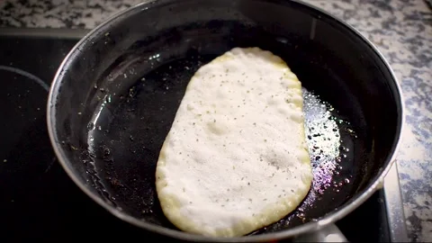 Frying homemade naan bread in pan, indian or asian bread. Cooking delicious n Stock Footage 133377251