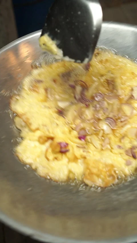 Frying homemade omelet with sliced shallots in a hot wok. Stock Footage 336196100