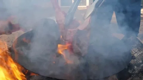 Frying juicy beef steak over a campfire while camping in the wilderness Stock Footage 338210849