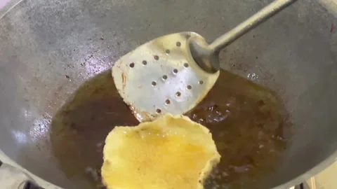 Frying kicimpring crackers in hot oil Stock Footage 324750853