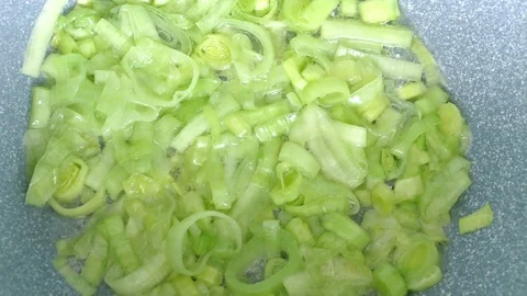 Frying leek in a pan Stock Footage 73042758