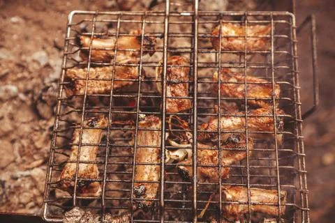 Frying meat over grill grid. Barbecue and cooking on the nature Stock Photos