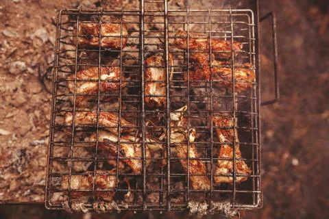 Frying meat over grill grid. Barbecue and cooking on the nature Stock Photos