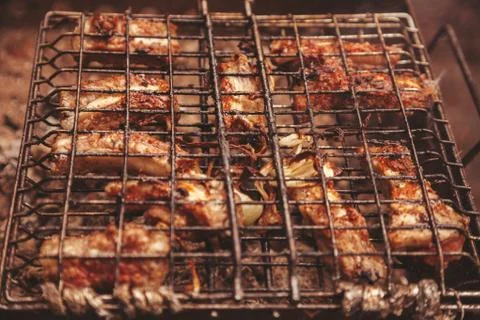 Frying meat over grill grid. Barbecue and cooking on the nature Stock Photos