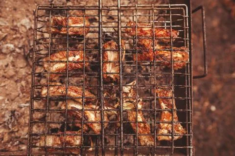 Frying meat over grill grid. Barbecue and cooking on the nature Stock Photos