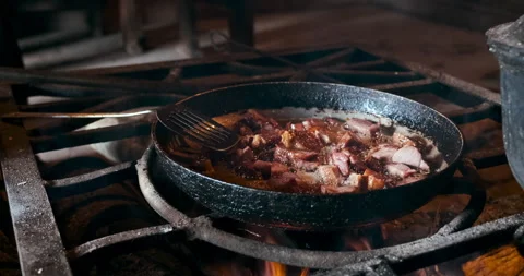 Frying meat in pan on the opened fire at fireplace in house inside indoors. Stock Footage 151157124