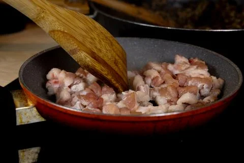Frying meat in a pan, pan-fried bacon, raw bacon fried in a pan for pierogi.. Stock Photos