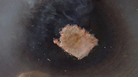 Frying meat on a tawa pan. Fried steak on hot pot turned with metal tongs Stock Footage 111629295