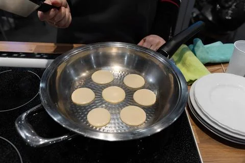 Frying mini pancake cereal in a nonstick frying pan. Stock Photos