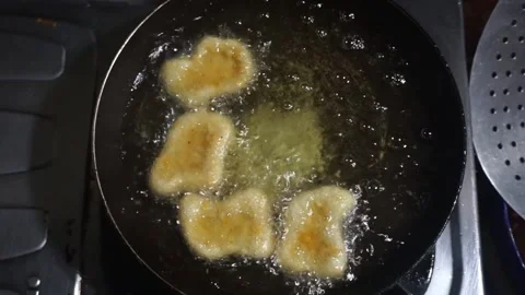 Frying nuggets in small pan for unhealty food video needs Stock Footage 293187033