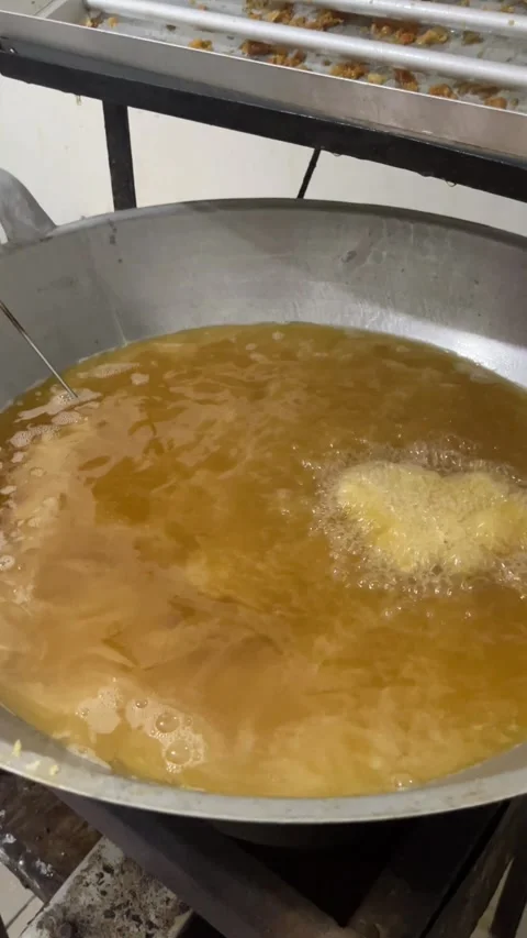 Frying Oil Bubbling in Large Pan with Golden Fried Dough Pieces in Busy Kitch Stock Footage 339874731