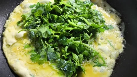 Frying omelet with corianders in pan, in door  Chiangmai  Thailand. Stock Footage 297521860