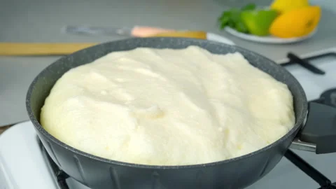 Frying omelet opening lid of frying pan turning cooking on kitchen gas stove. Stock Footage 313130895