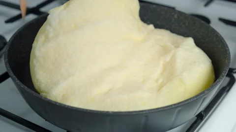 Frying omelet opening lid of frying pan turning it cooking on kitchen gas stove. Stock Footage 313130997