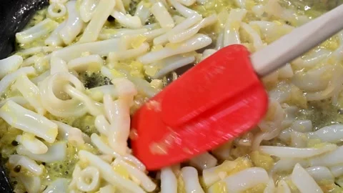 Frying onion and cuttlefish in the pan. To prepare a paella Stock Footage 219716971
