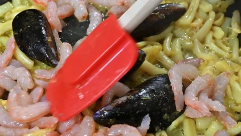Frying onion and cuttlefish in the pan, with mussels and prawns Stock Footage 219717497
